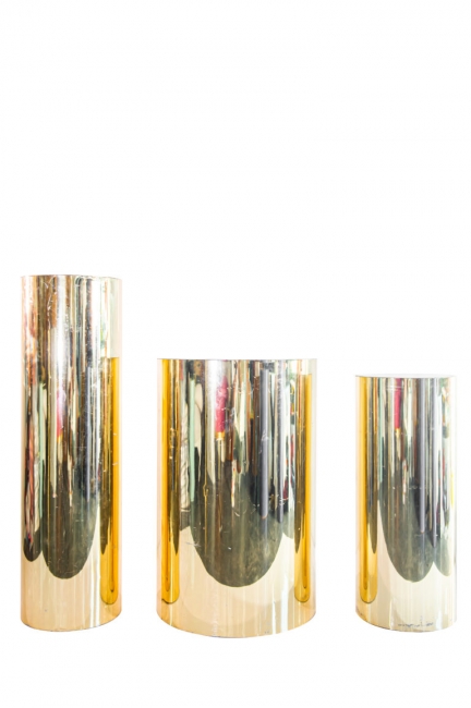 Trio of metallic gold display columns