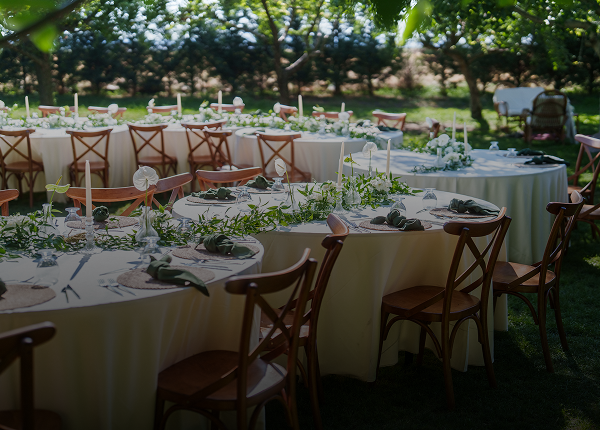 Outdoor wedding reception tables with greenery