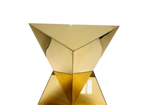 Golden geometric sculpture on white background