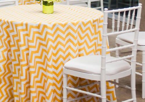 Yellow chevron tablecloth with white chairs