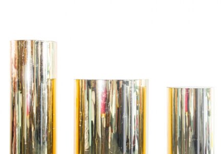 Trio of metallic gold display columns